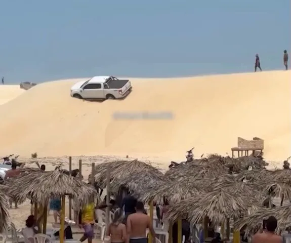 Motorista tenta atravessar duna em praia do Ceará e caminhonete fica inclinada